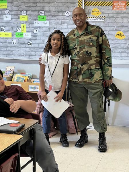 Veteran Mr. Lucas standing with a student in a classroom.